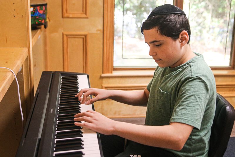 A boy playing the piano as part of Music Therapy.