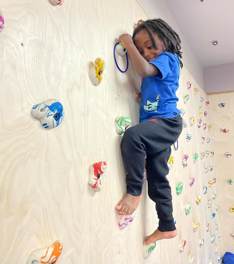 A girl climbing a rock wall as part of Physical Therapy.